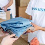 cropped view of volunteer giving clothes to woman 2022 12 16 21 31 45 utc